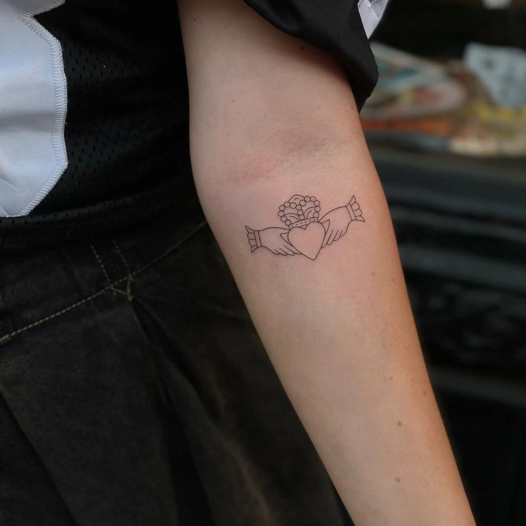 Small fine line Claddagh ring tattoo at XOXO Dublin