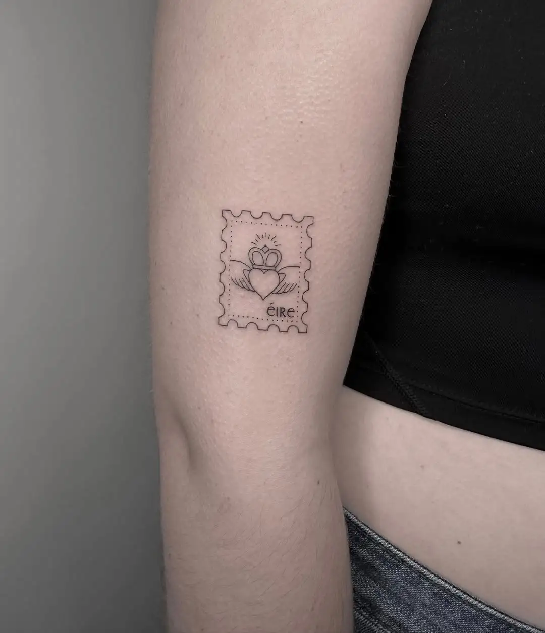 Delicate Éire Claddagh postage stamp tattoo at XOXO Dublin
