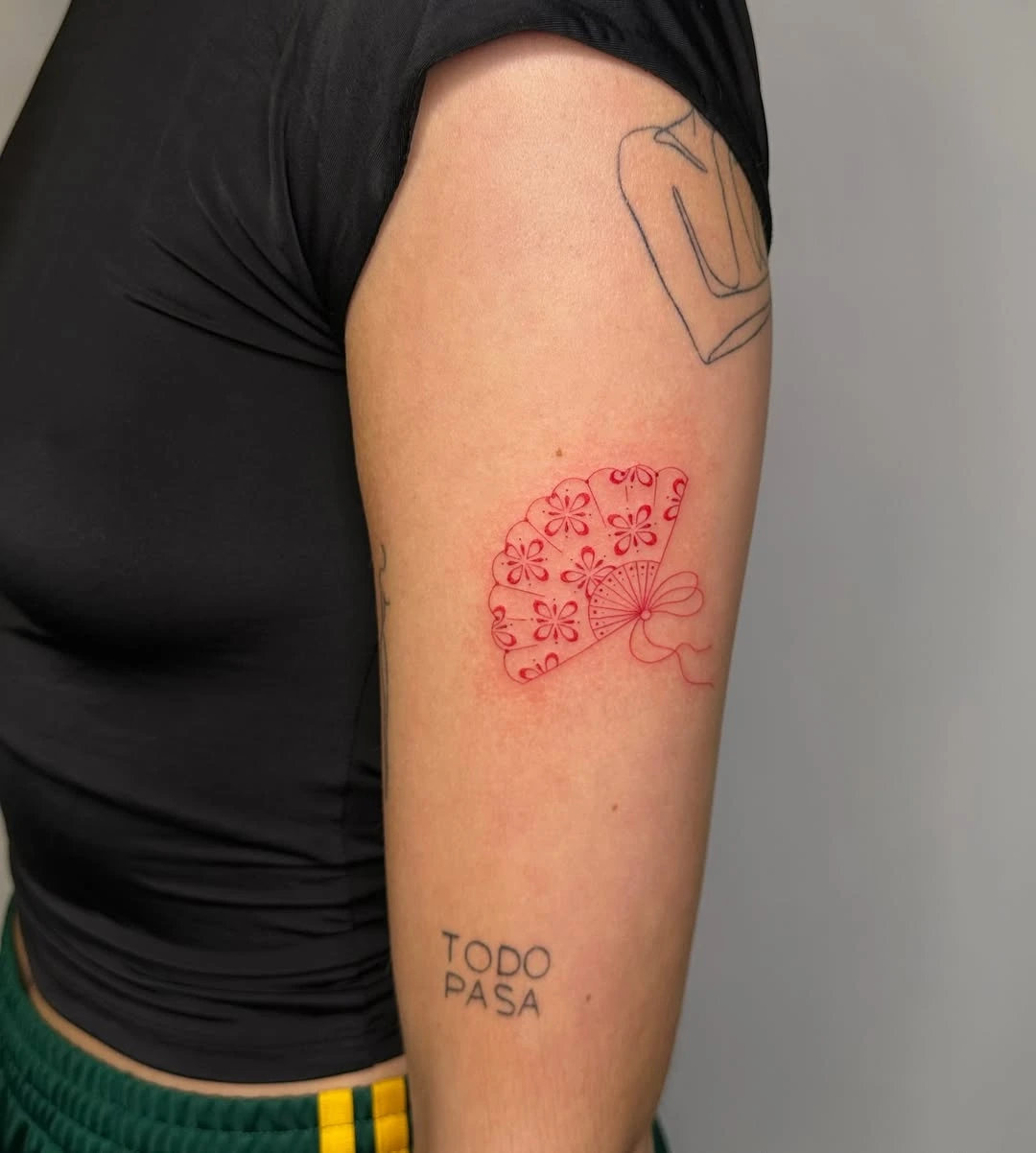 Small red ink oriental fan tattoo at XOXO Dublin