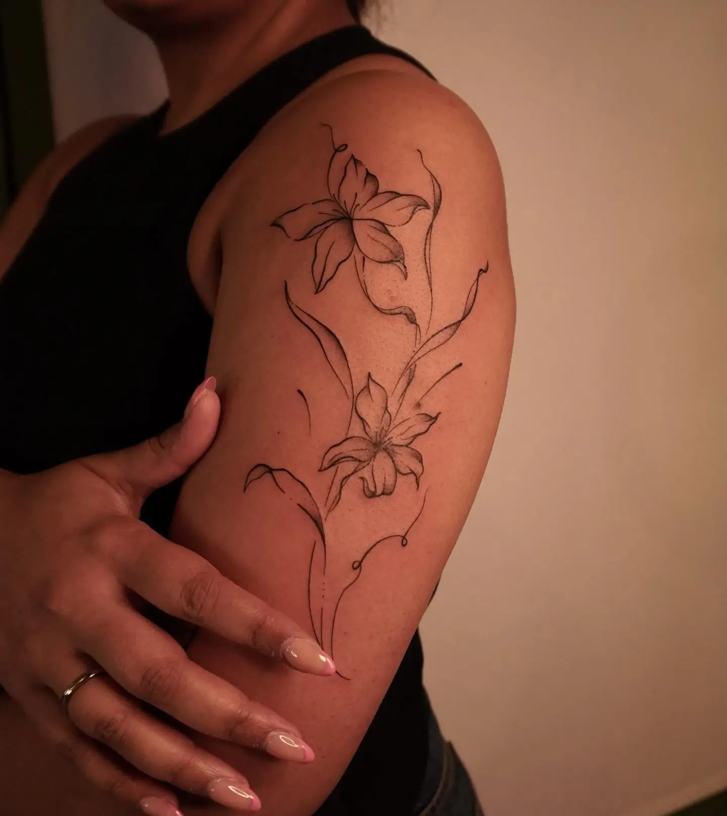 Fine-line lily flowers tattoo by Christine Bevilaqua at XOXO Dublin