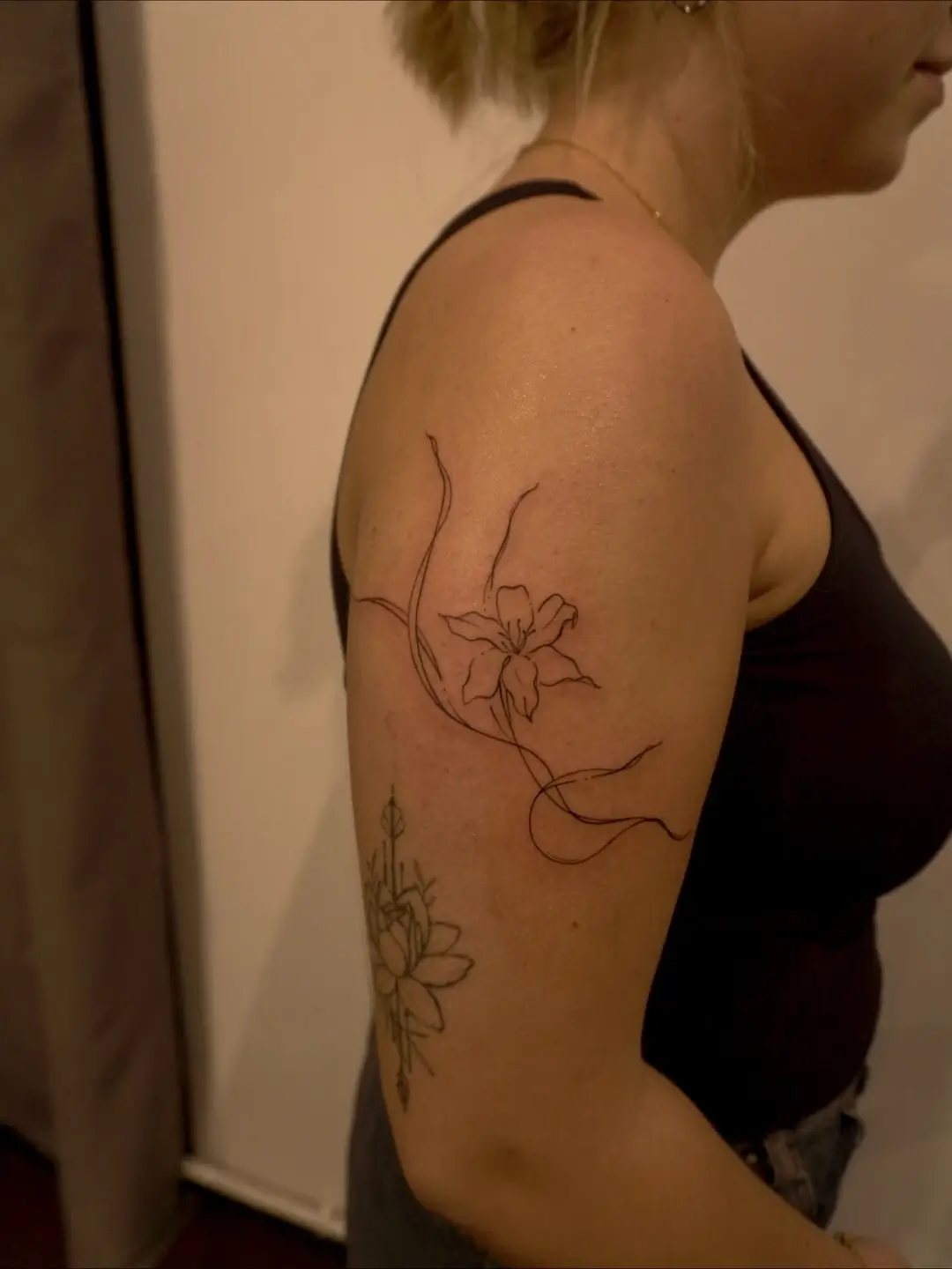 Fine-line orchid and vine tattoo by Christine Bevilaqua at XOXO Dublin