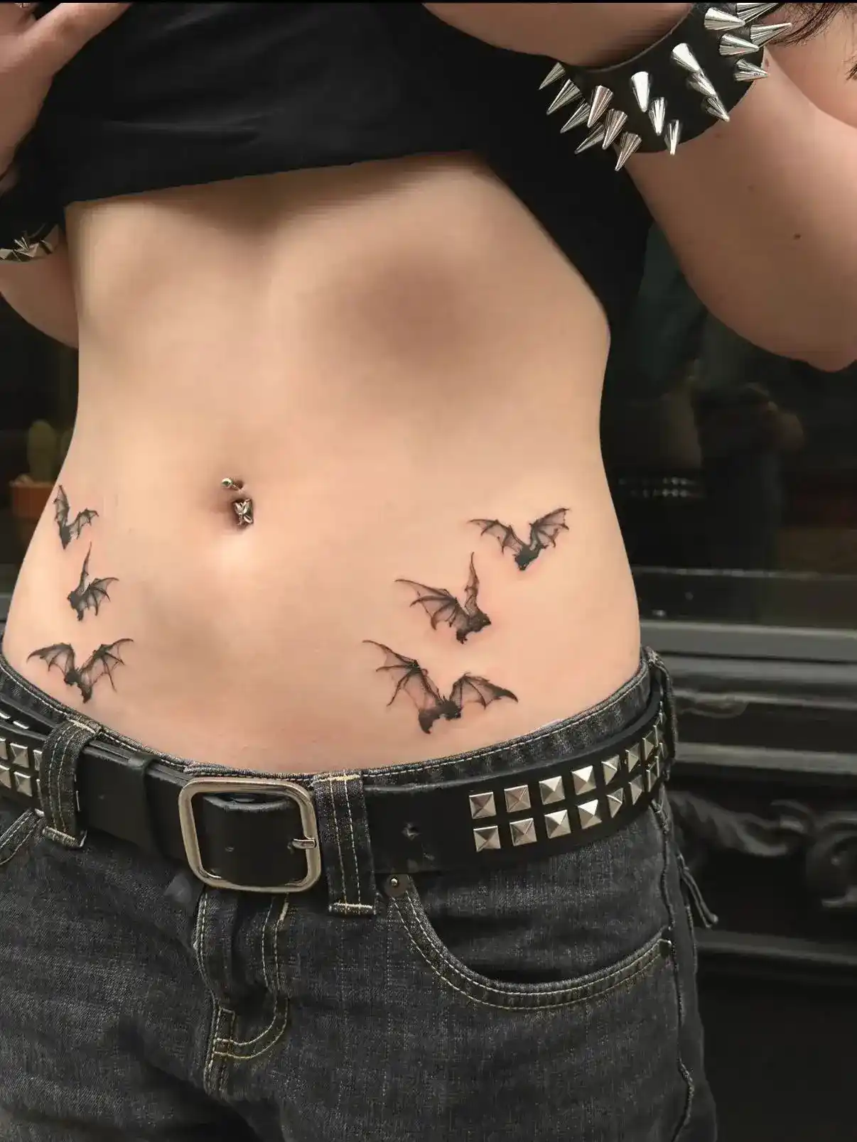 Fine-line flock of bats tattoo on waist by Gabriel Vendra at XOXO Dublin