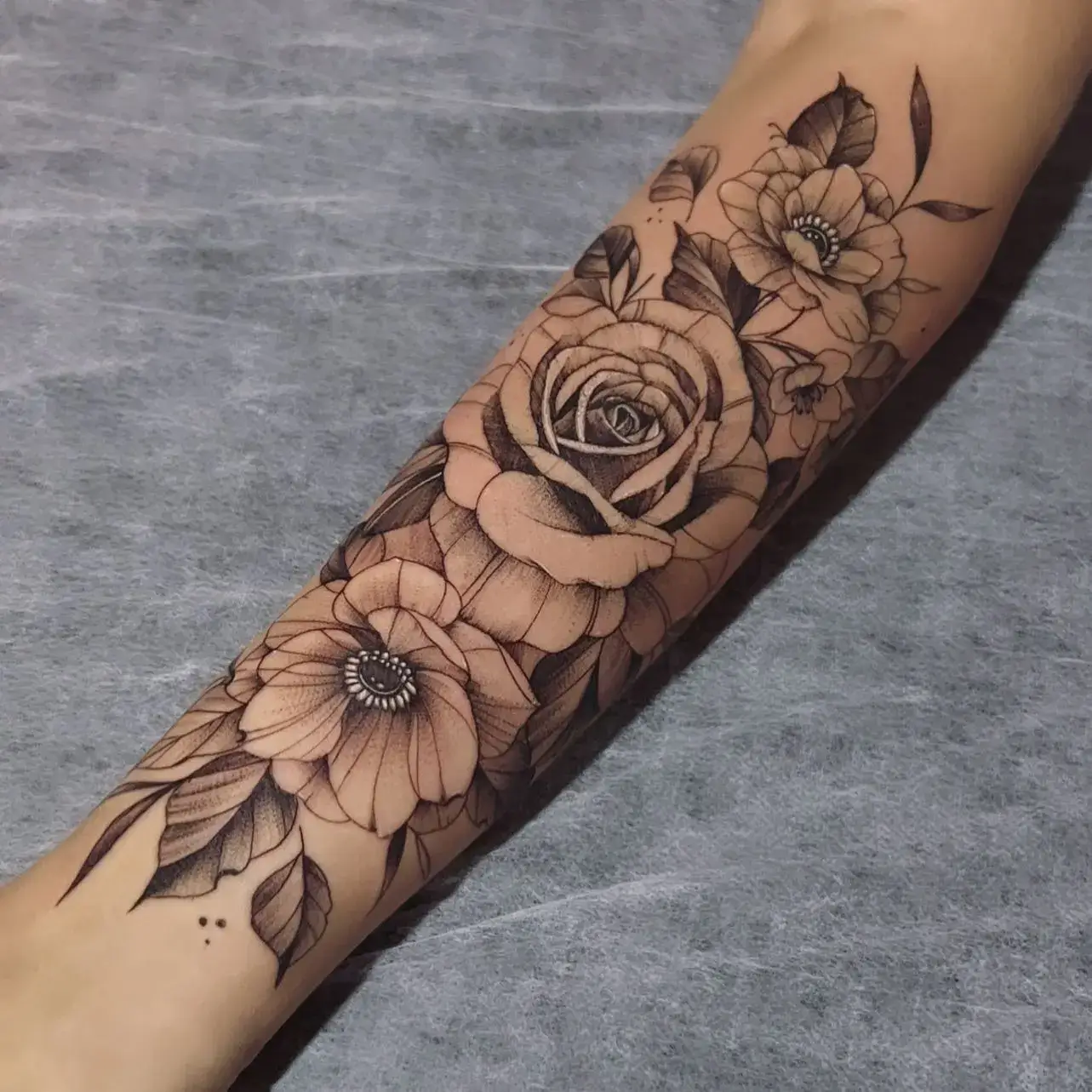 Black and grey rose and flower forearm tattoo by Paulo Rodrigues, XOXO Dublin